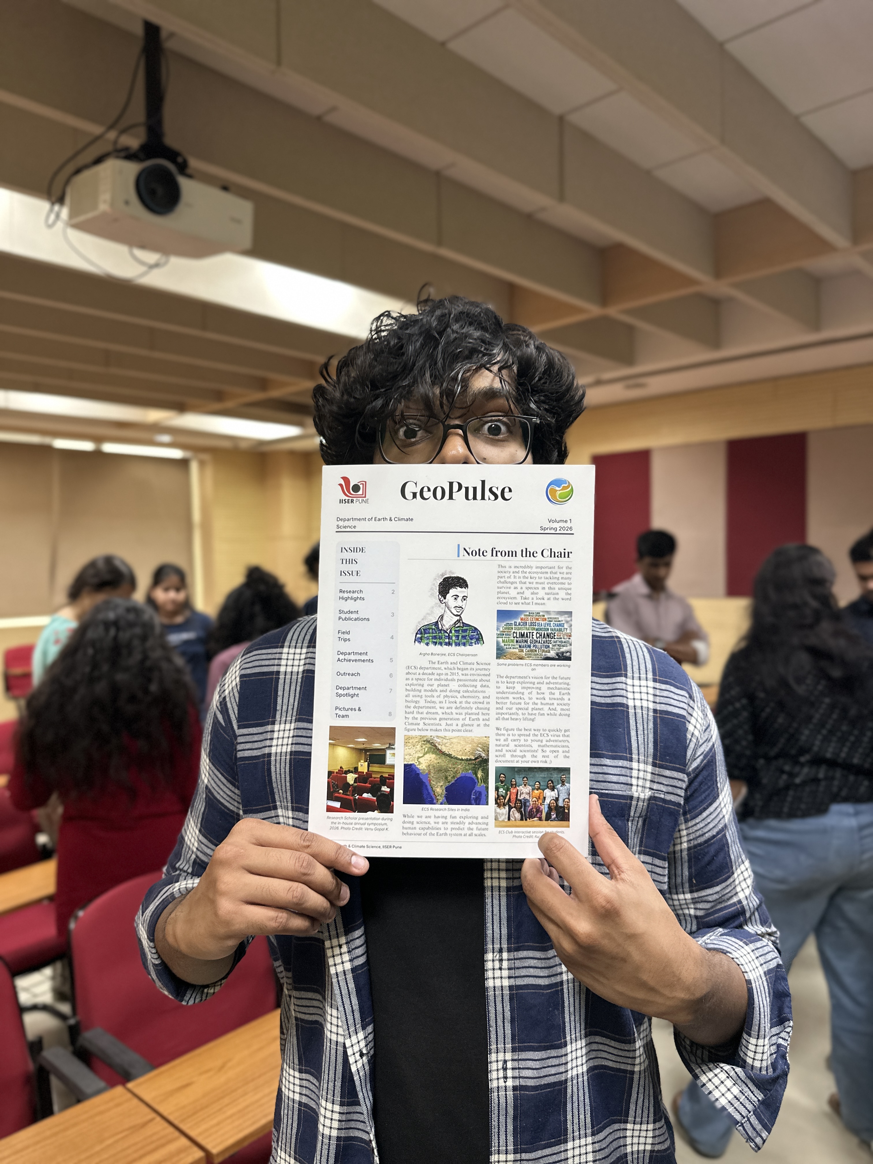 Naityik holding the printed GeoPulse newsletter